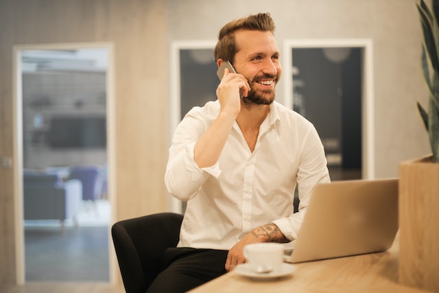 property-manager-on-phone-sitting-down-at-desk-smiling