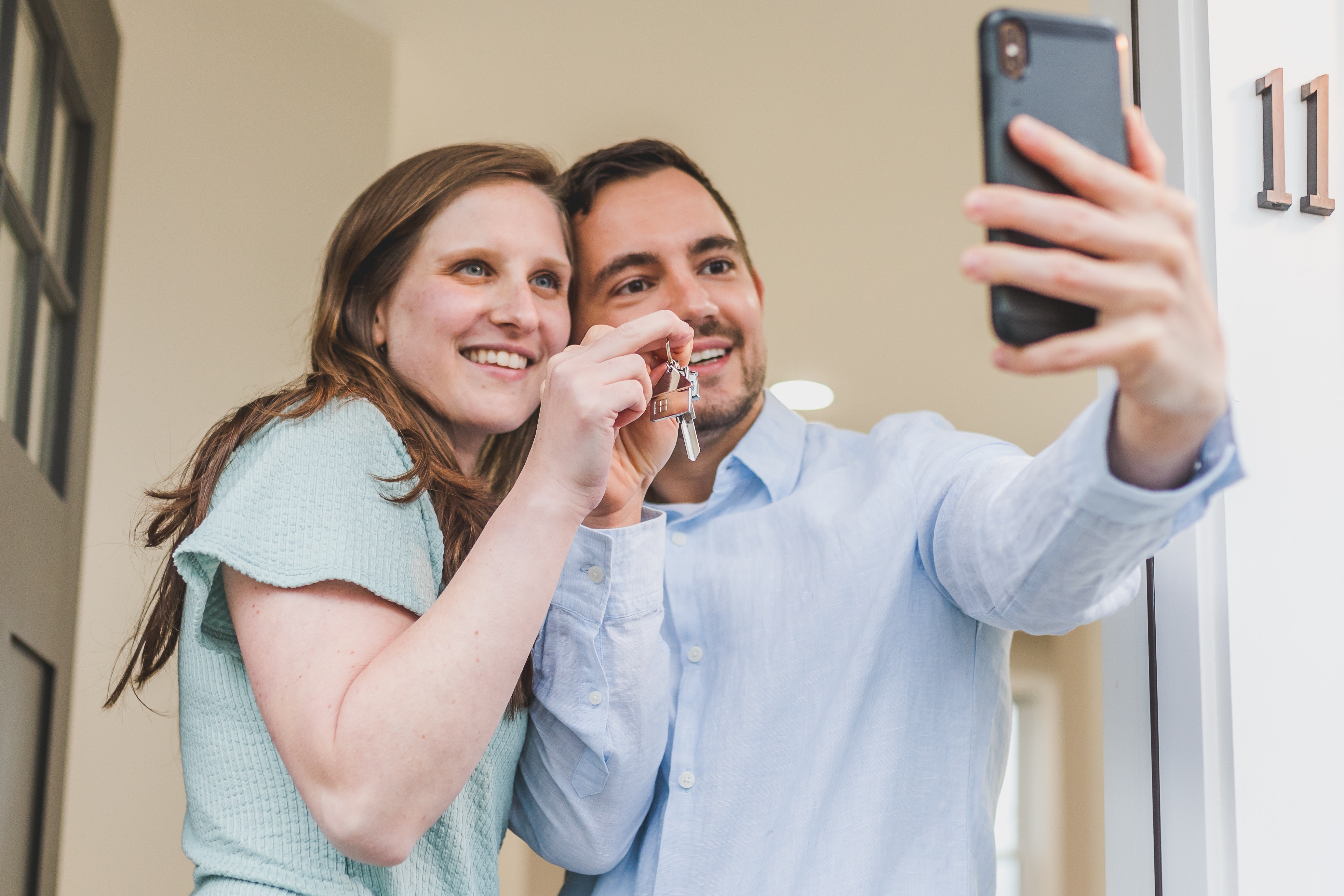 A couple taking a selfie with the keys to their new home.
